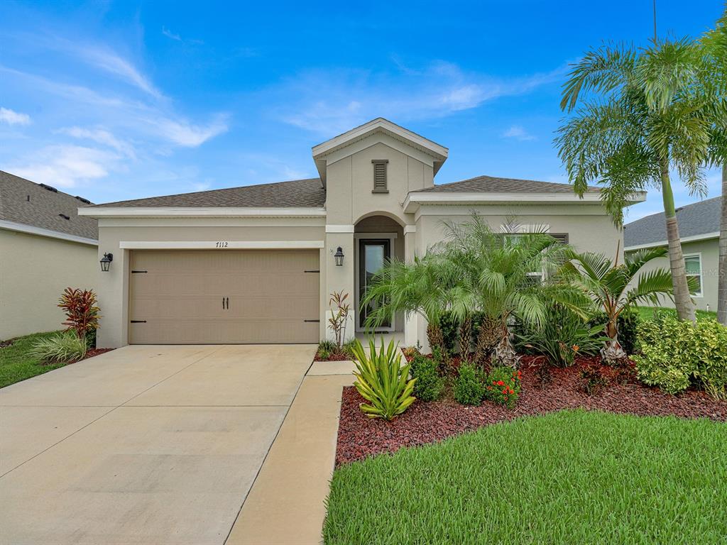 a front view of a house with a yard and garage