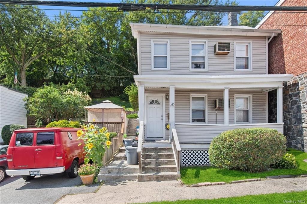 a front view of a house with a yard and outdoor seating