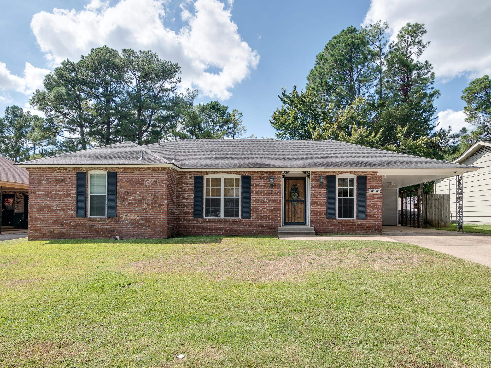 Ranch-style house featuring a front lawn and a carport