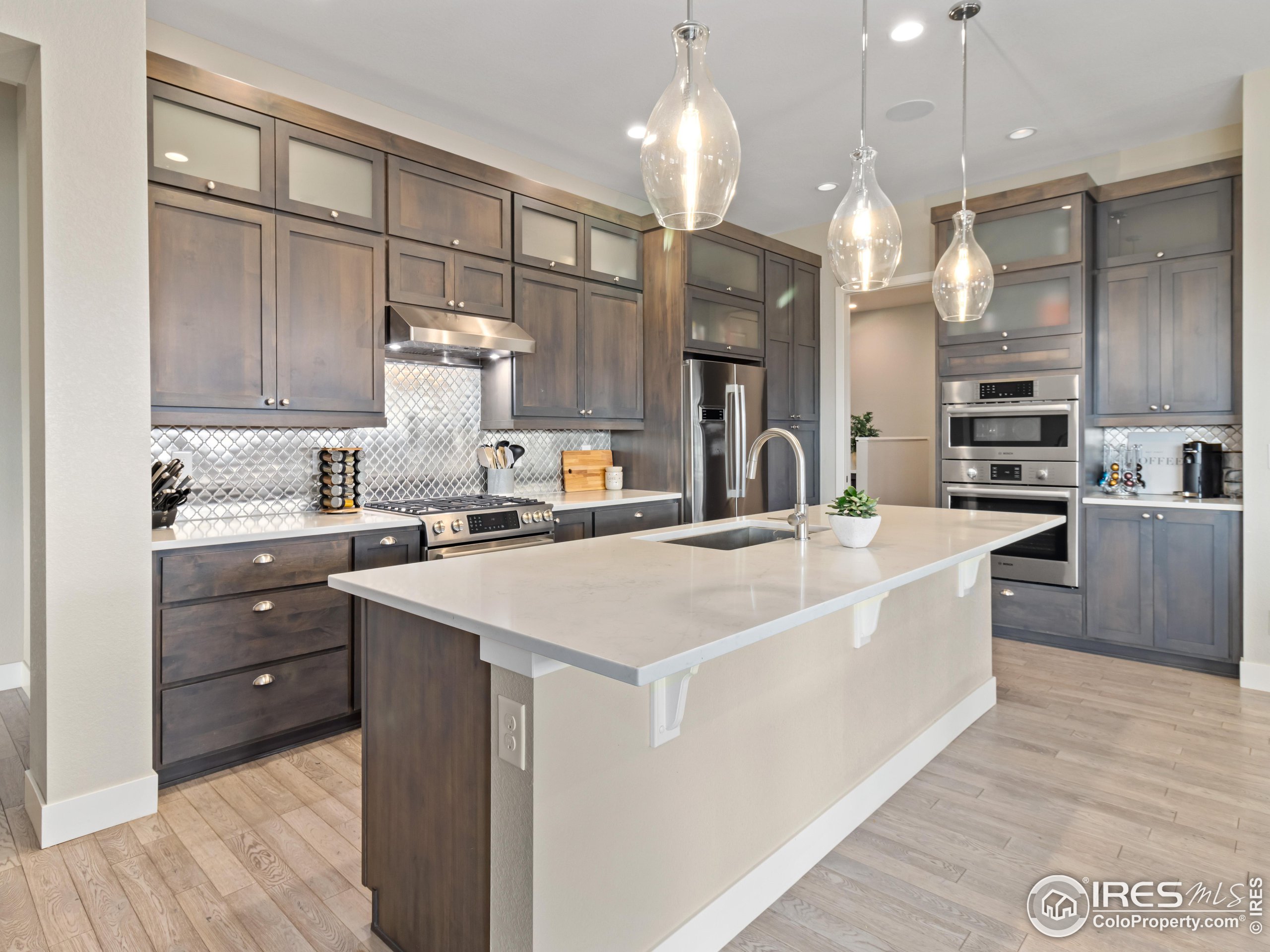 a large kitchen with kitchen island a stove a sink a center island and cabinets