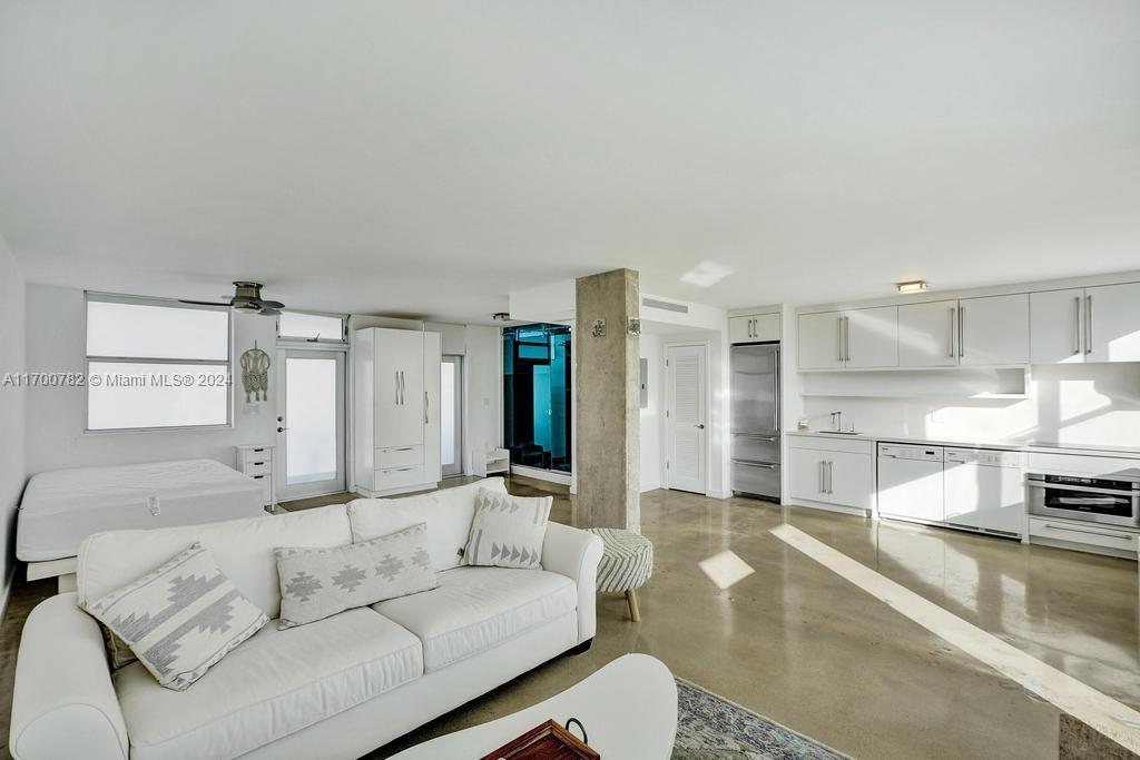 a living room with furniture and a kitchen view