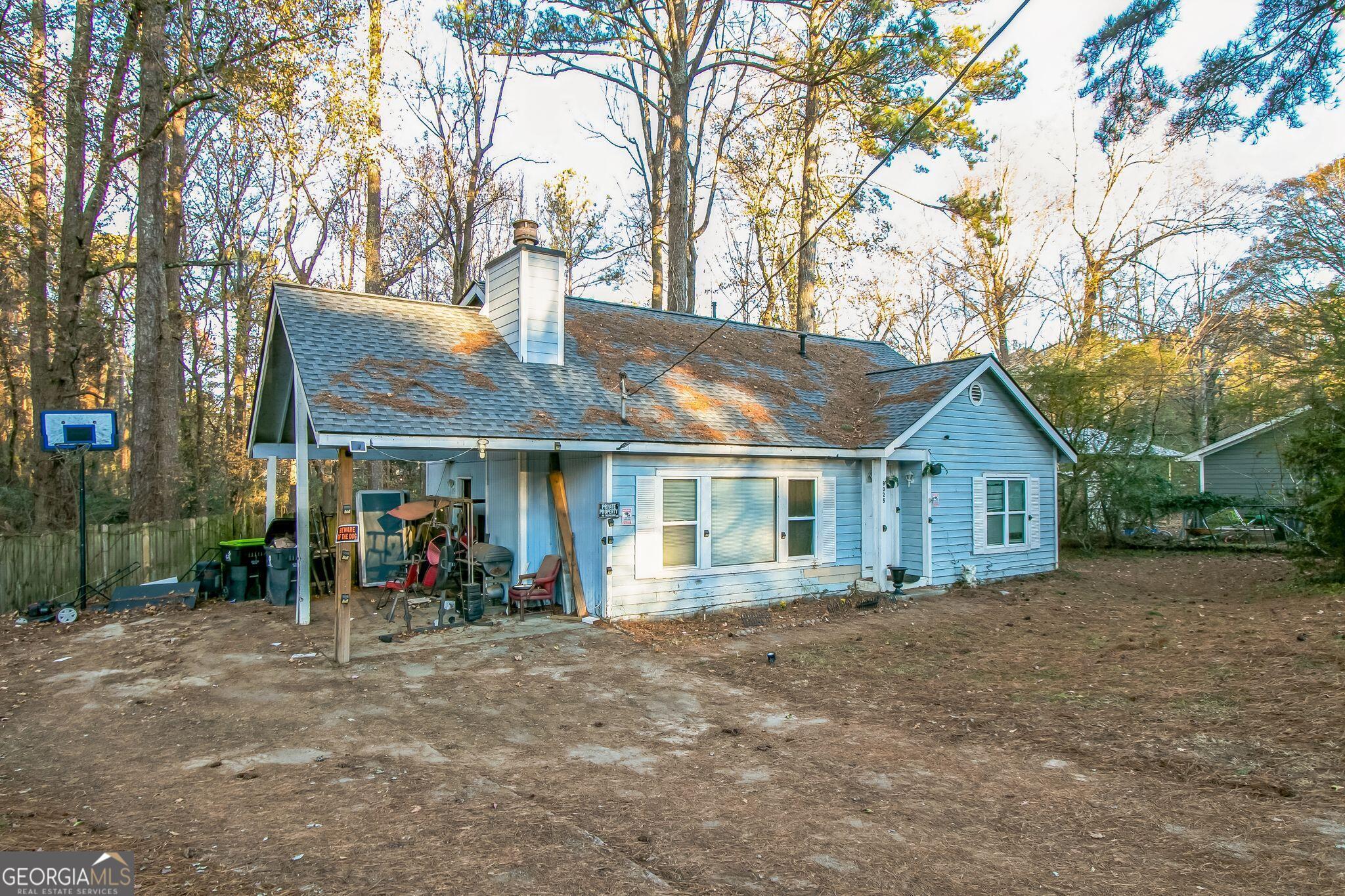 a view of a house with a yard and large trees