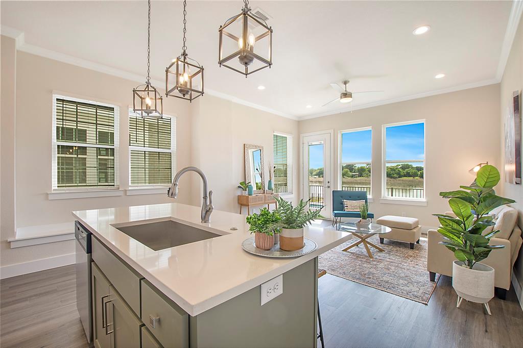 a kitchen with a table a potted plant and couches