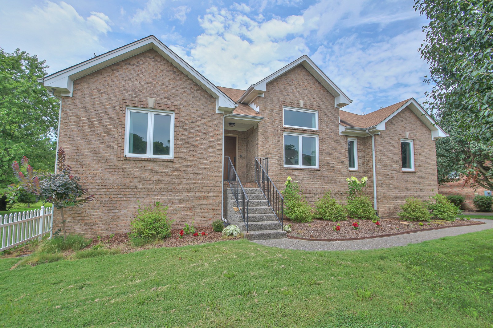 a front view of a house with a garden and plants