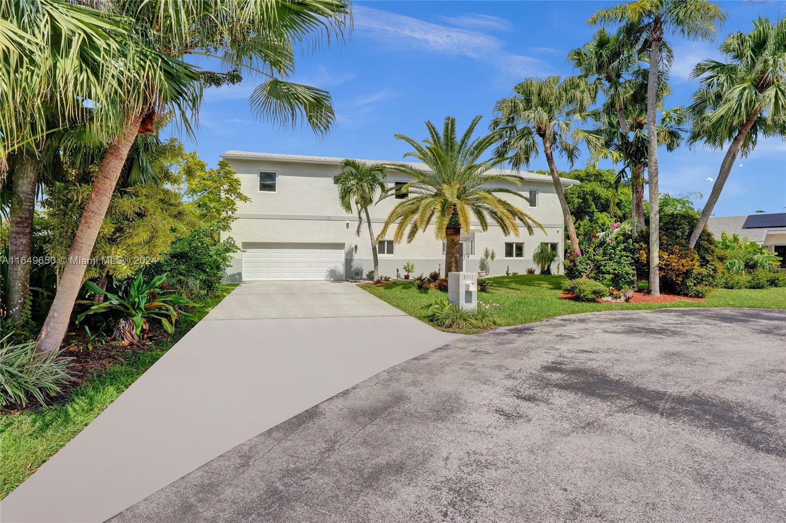 a couple of palm trees in front of yellow house