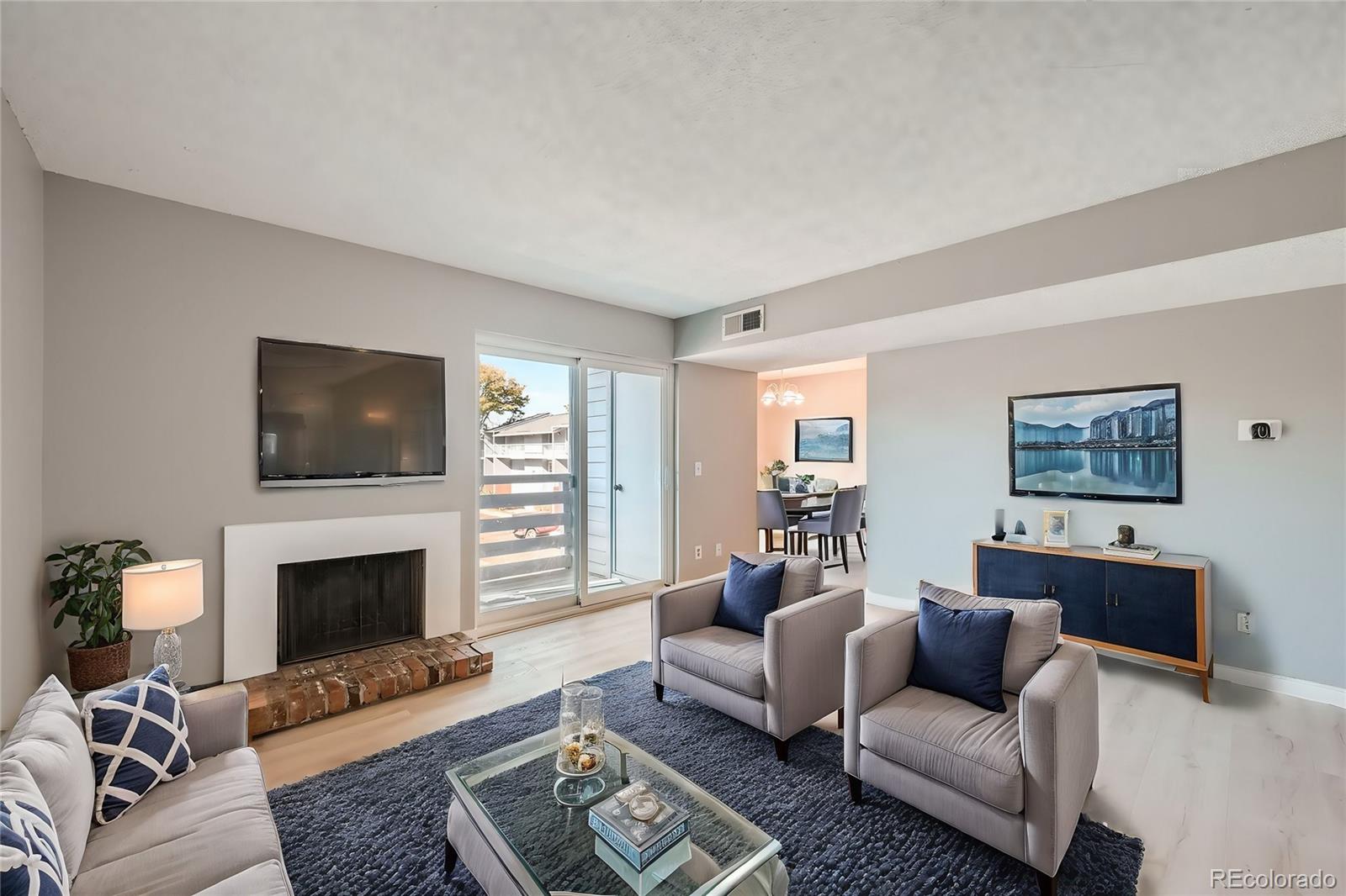 a living room with furniture a flat screen tv and a fireplace