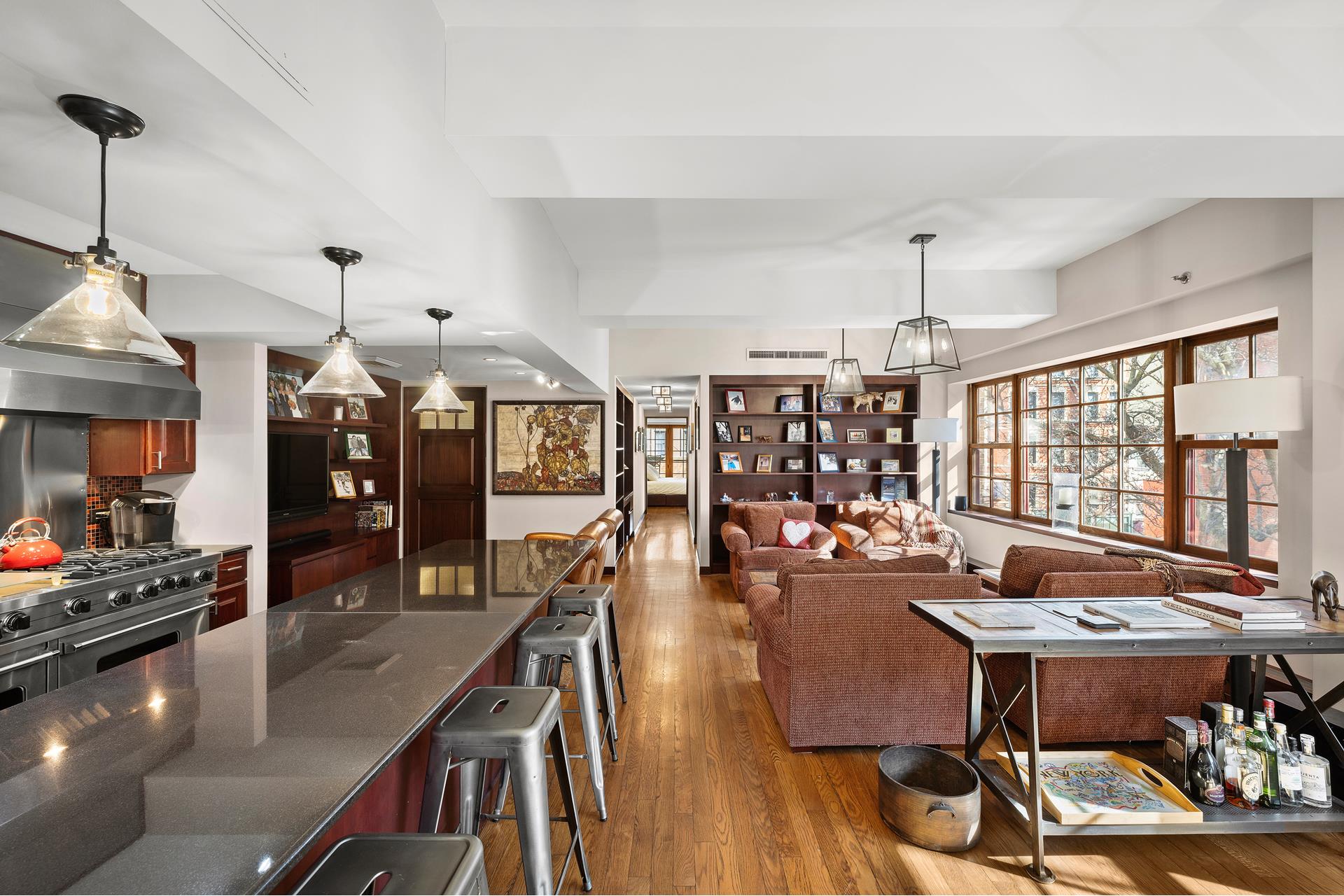 a view of a dining room and livingroom with furniture wooden floor a chandelier