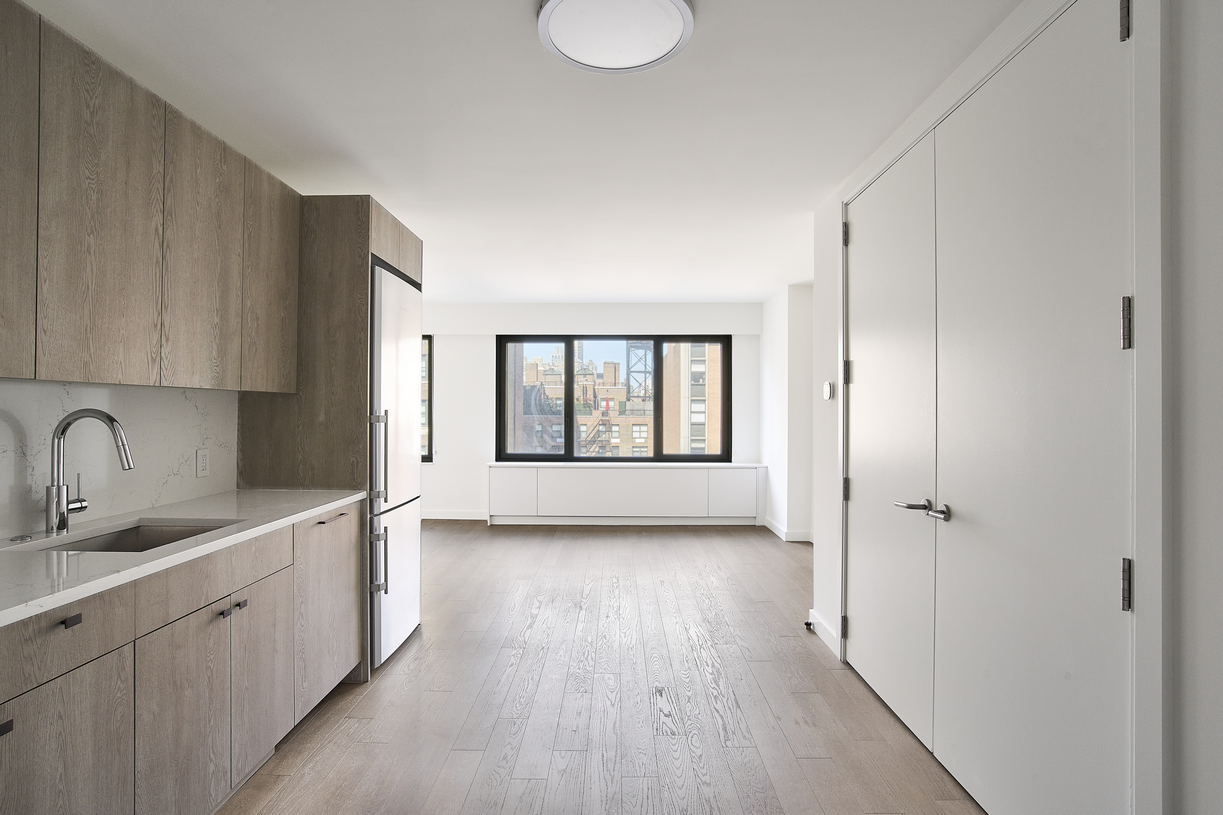 a view of a kitchen with a sink and dishwasher with wooden floor