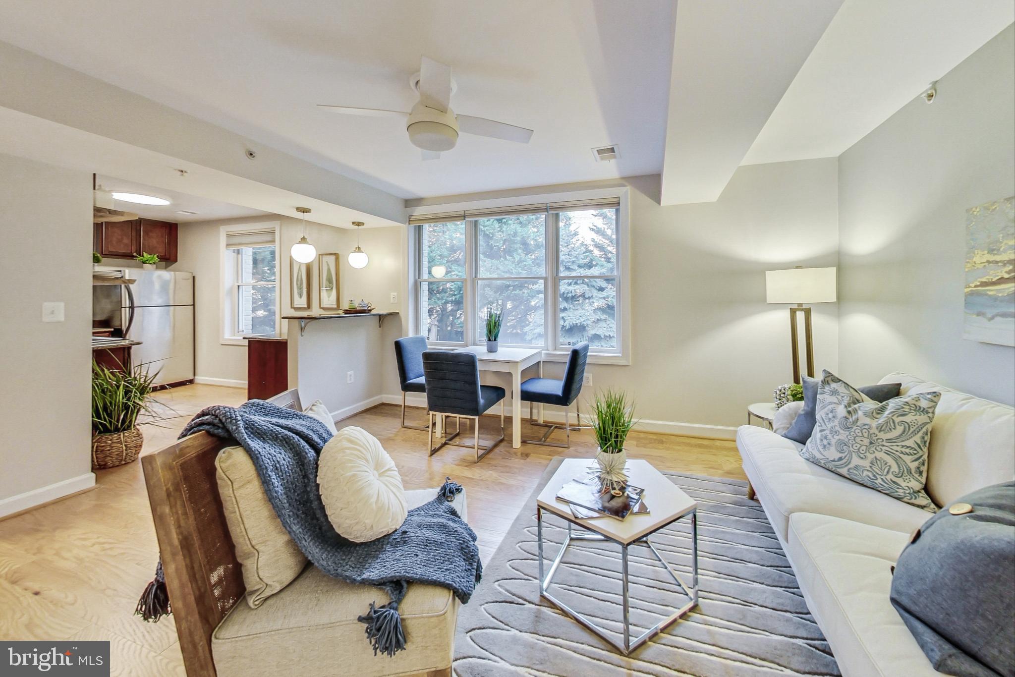 a living room with furniture a lamp and wooden floor