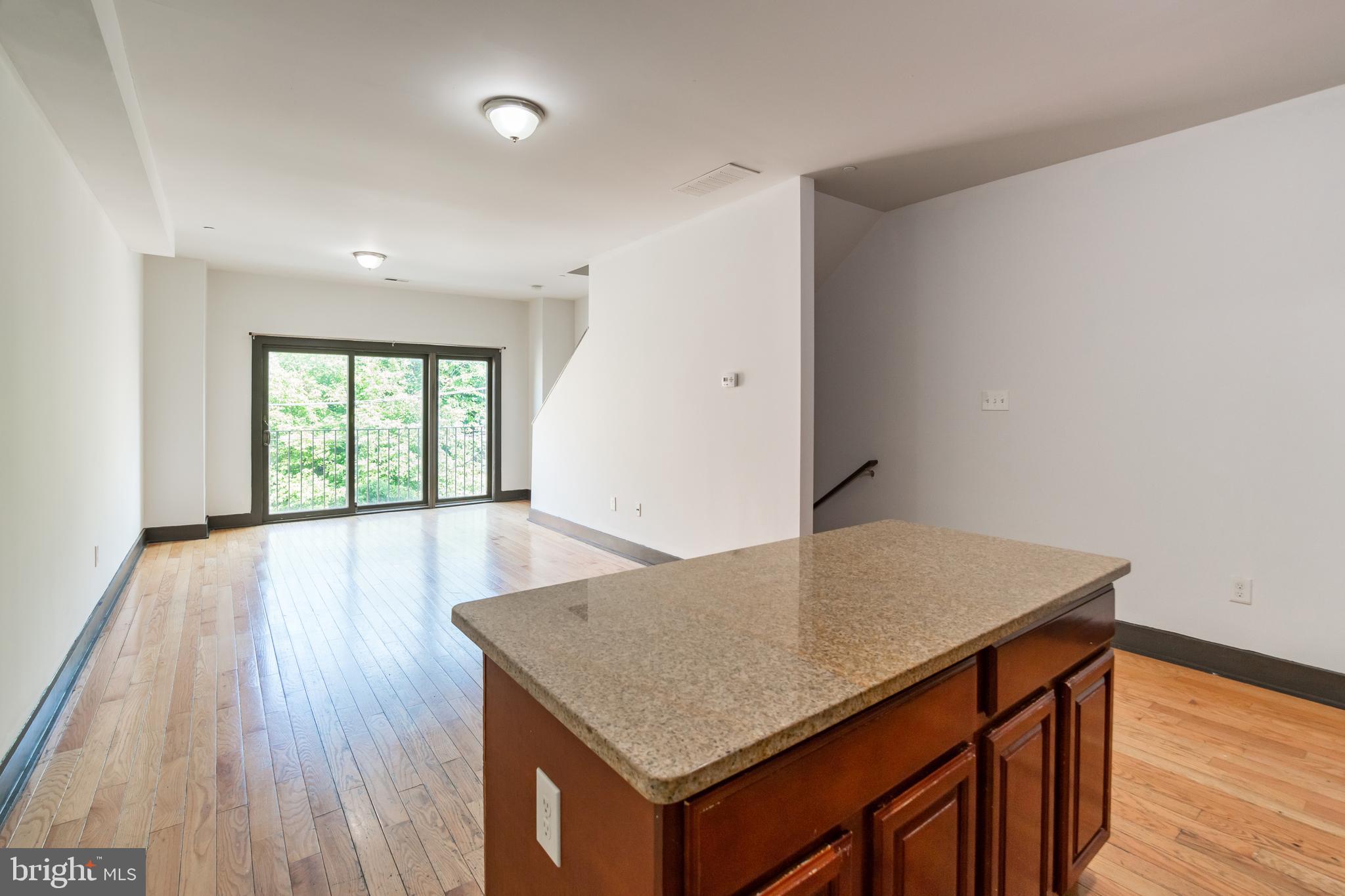 an empty room with wooden floor and window