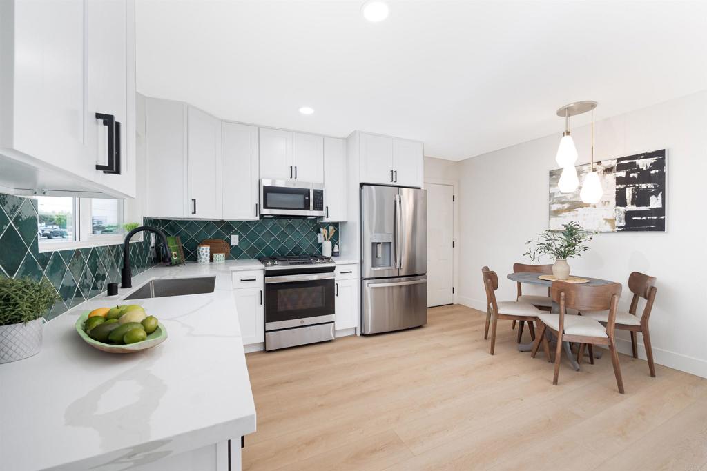 a kitchen with refrigerator and chairs