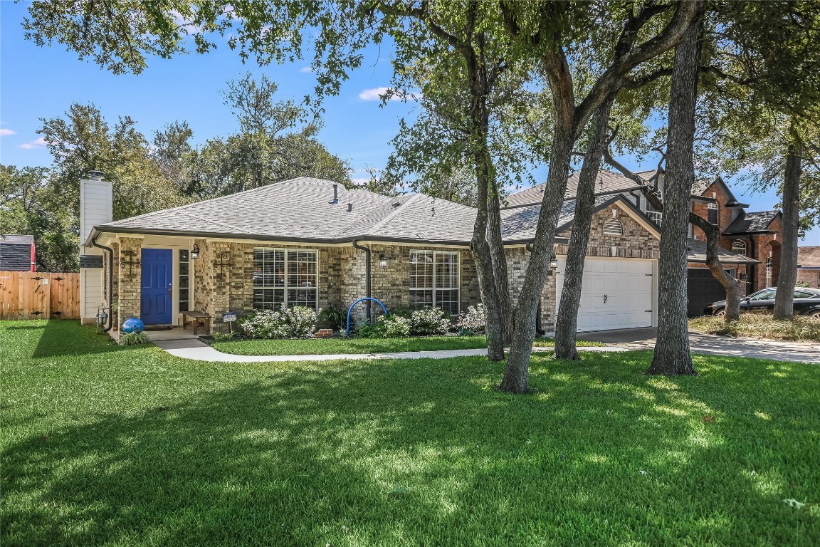 a front view of a house with a yard and trees