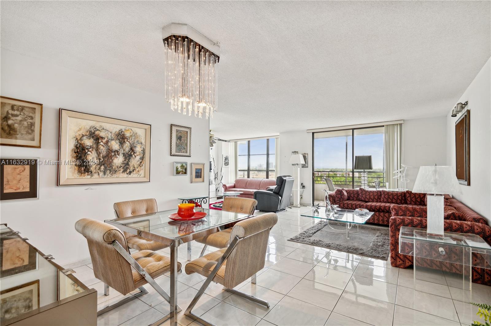 a living room with furniture a fireplace and a chandelier