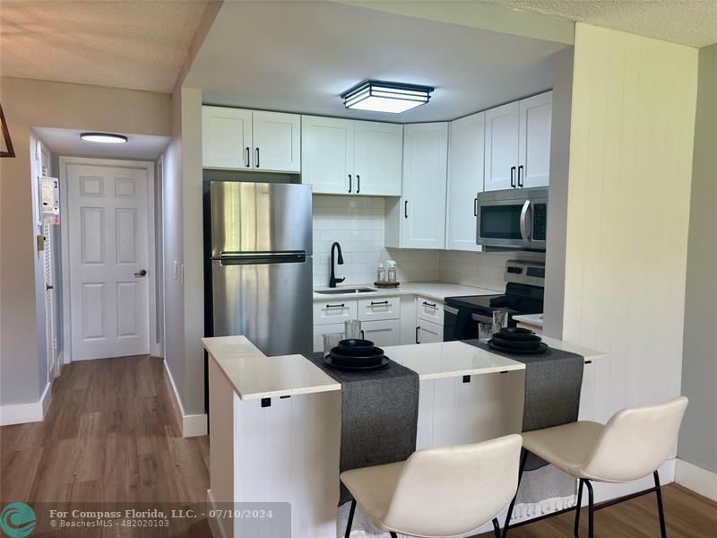 a kitchen with a refrigerator a stove a sink and a cabinets