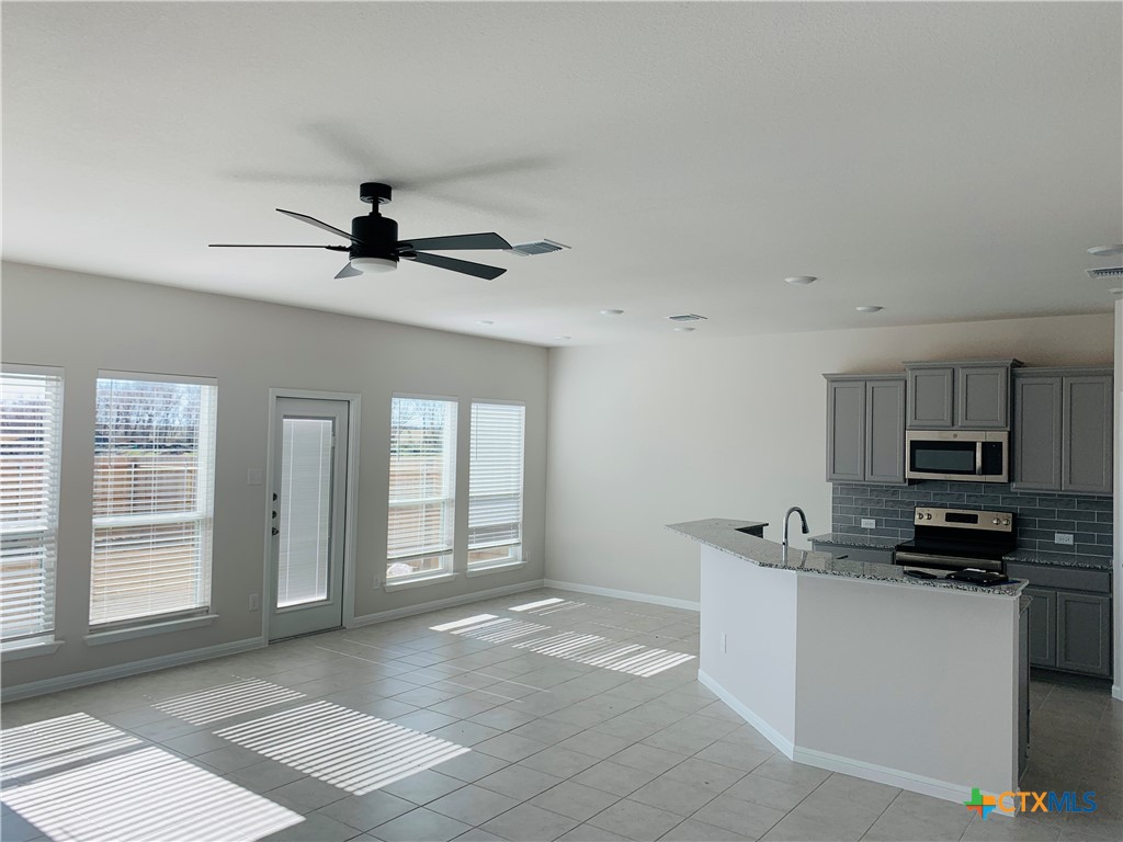 a view of a kitchen with microwave and windows