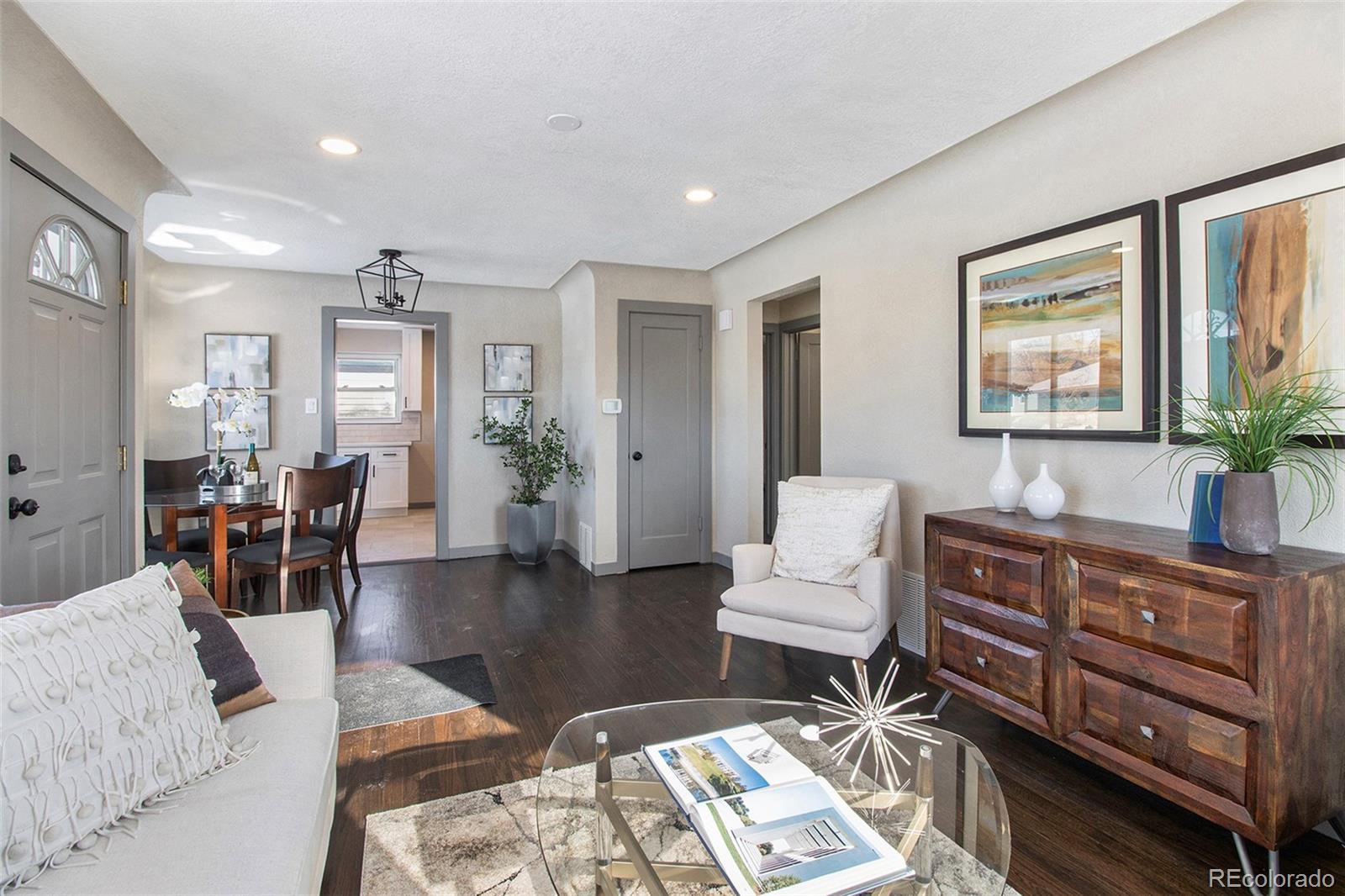 a living room with furniture a wooden floor and a large window