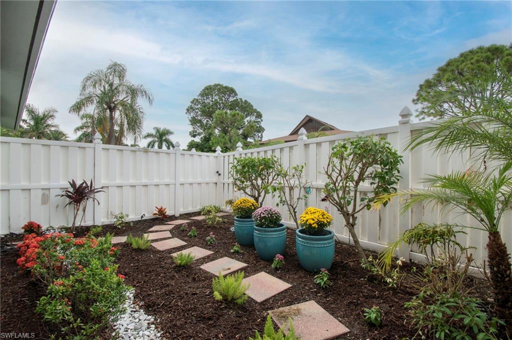 a backyard of a house with lots of green space and fountain in the back