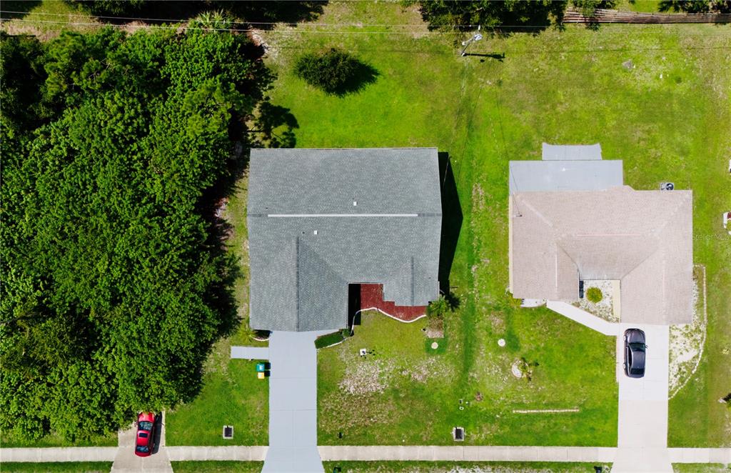 an aerial view of a house with a yard basket ball court and outdoor seating