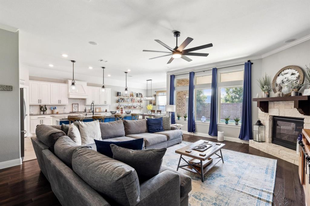 a living room with furniture kitchen view and a large window