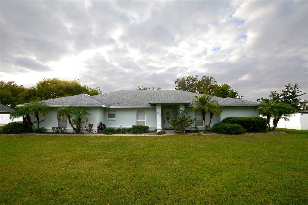 a front view of a house with a garden and trees