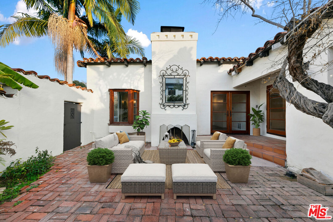 front view of a house with potted plants and a chair