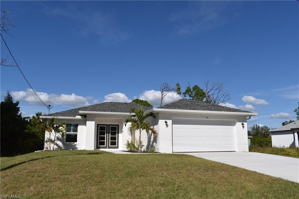 a front view of a house with a yard and garage