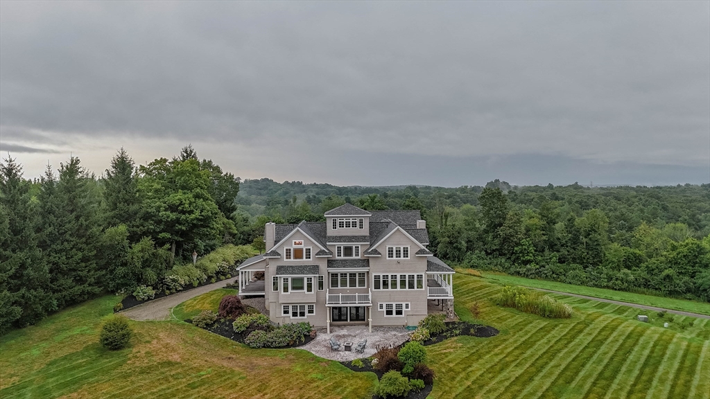 a view of a big house with a big yard and large trees