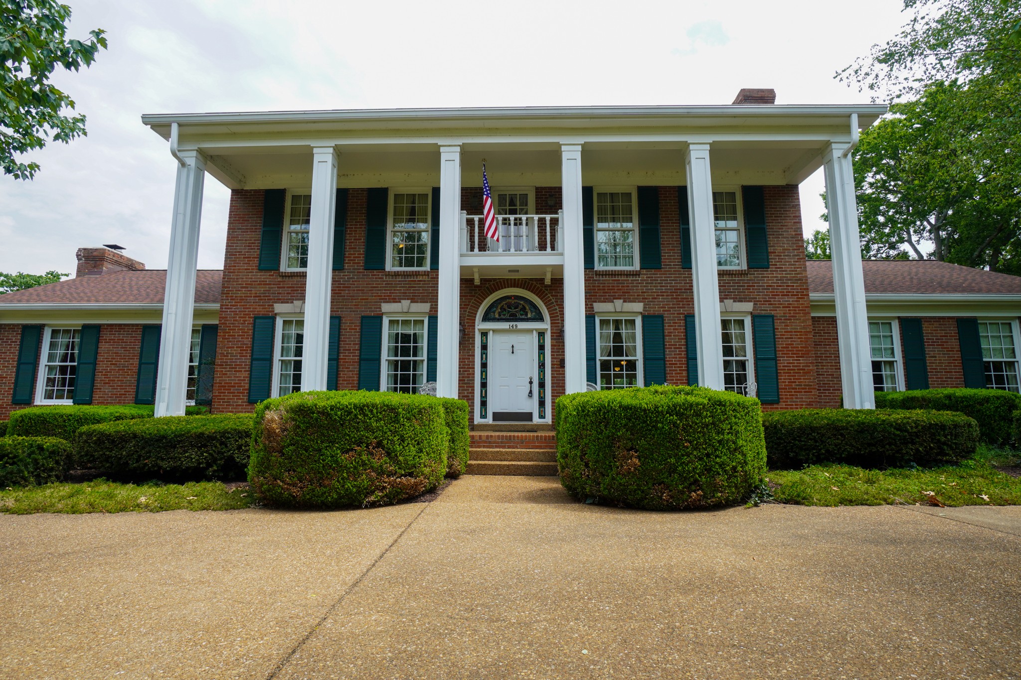 front view of a brick house with a yard