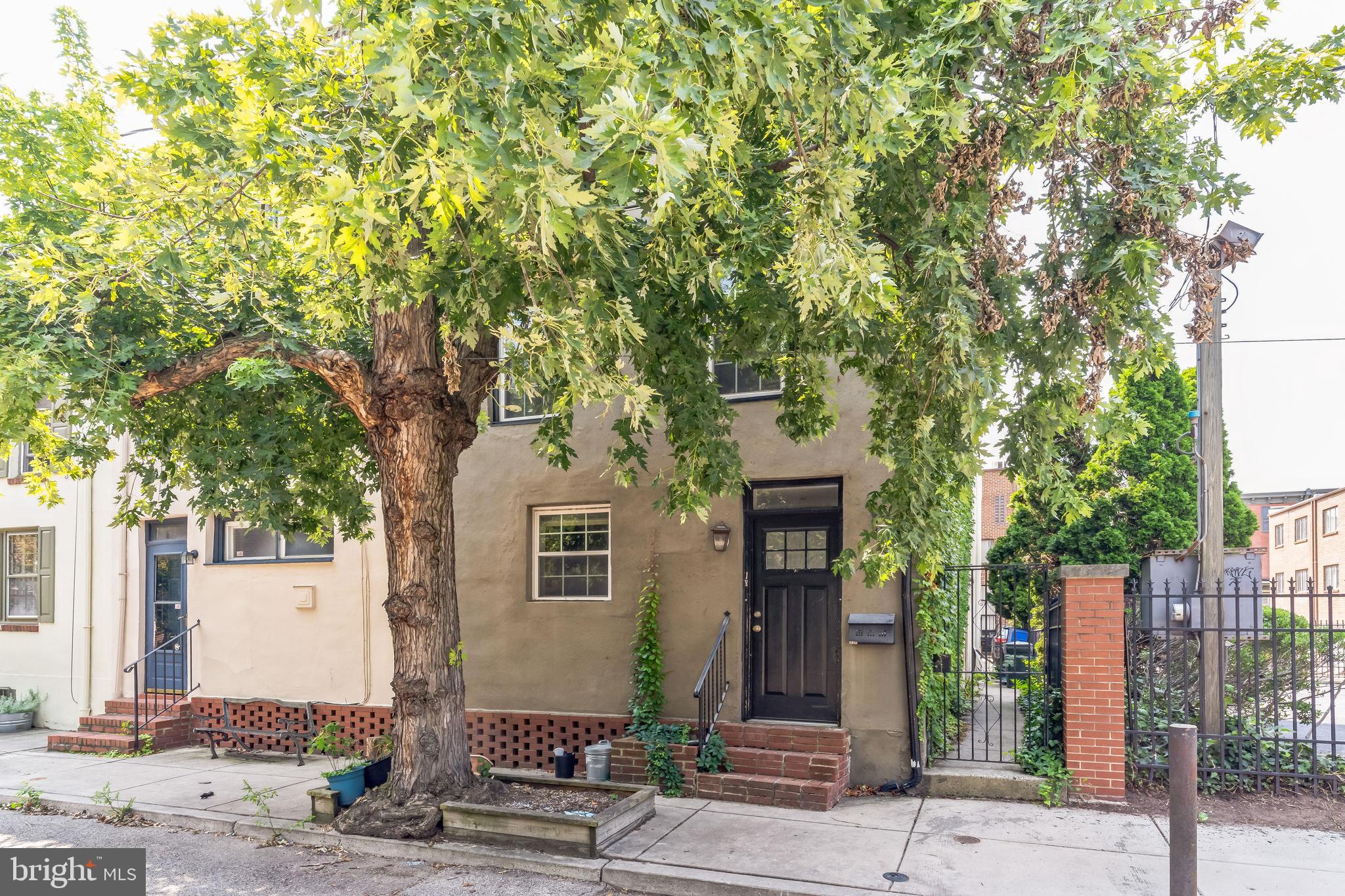 a front view of a house with a tree