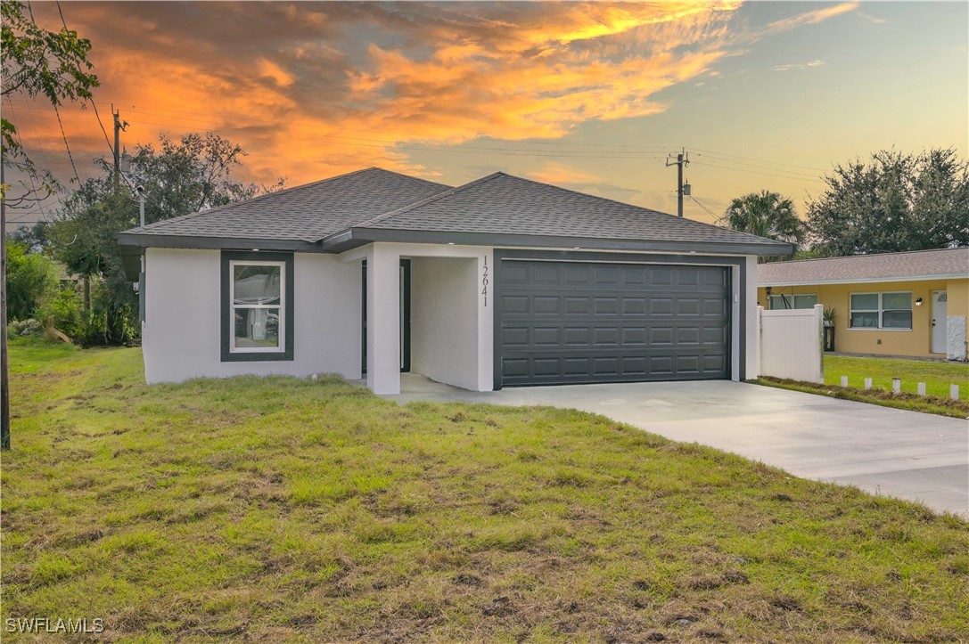 a front view of a house with a yard and garage