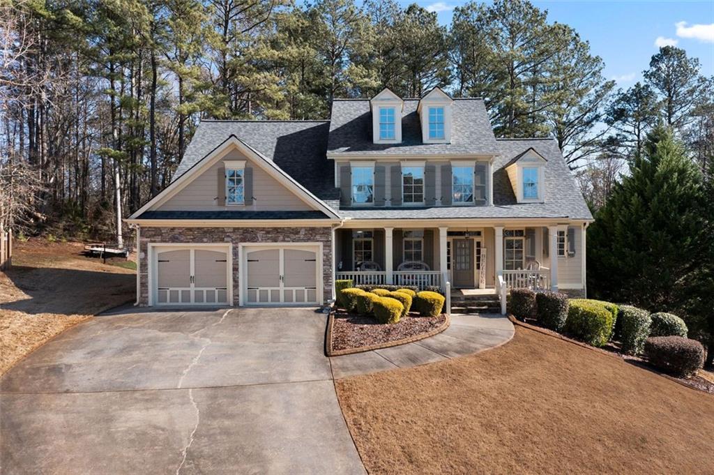 a front view of a house with sitting area and trees