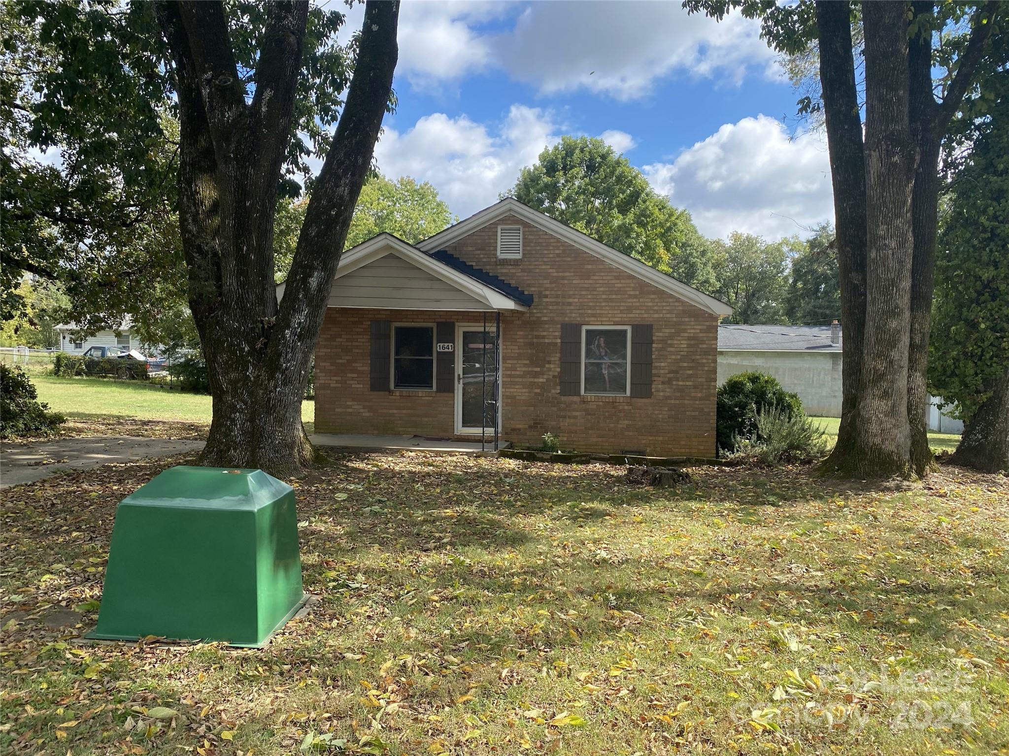 a view of a house with backyard and a tree