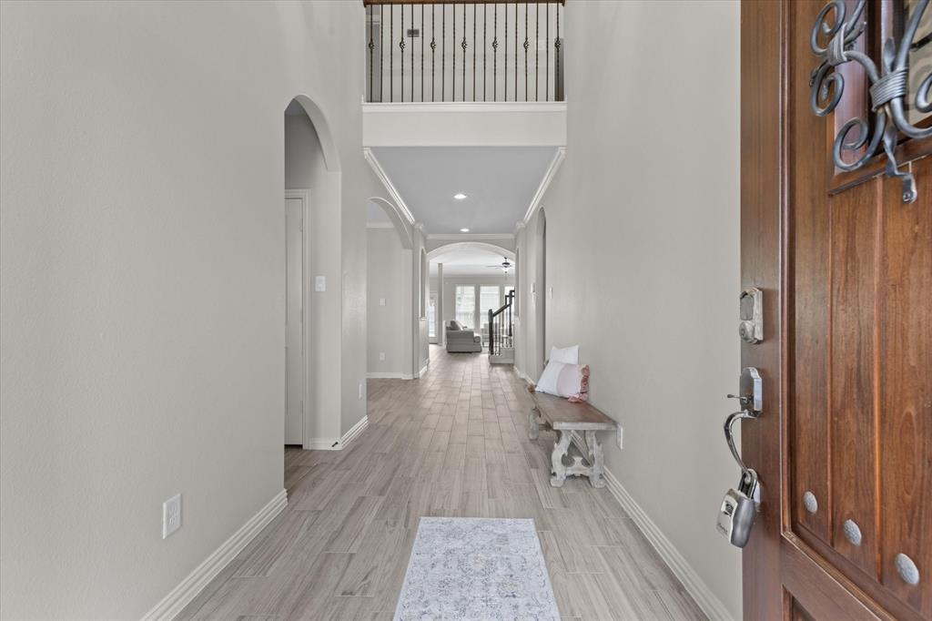 a view of a hallway with wooden floor and a bathroom