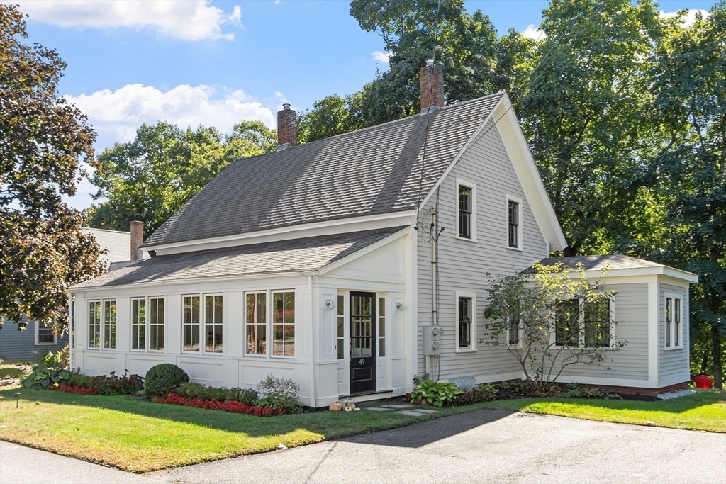 a view of a white house with a yard and plants