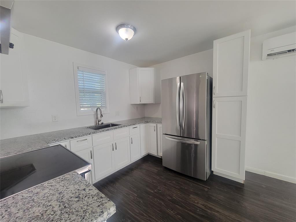 a kitchen with a refrigerator wooden floor and a sink