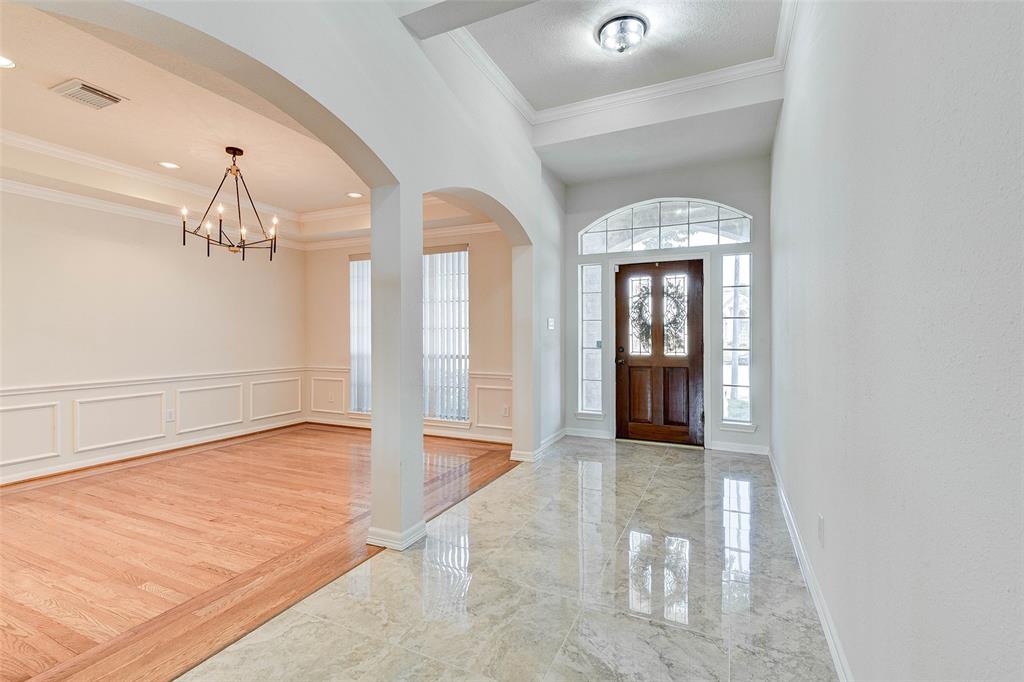 The foyer has a wide entrance with updated gleaming floors, lighting and fresh paint.