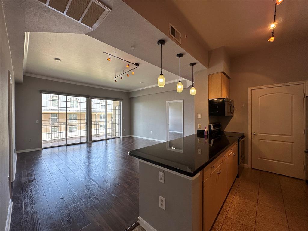 a kitchen with granite countertop a refrigerator a sink dishwasher and wooden floor