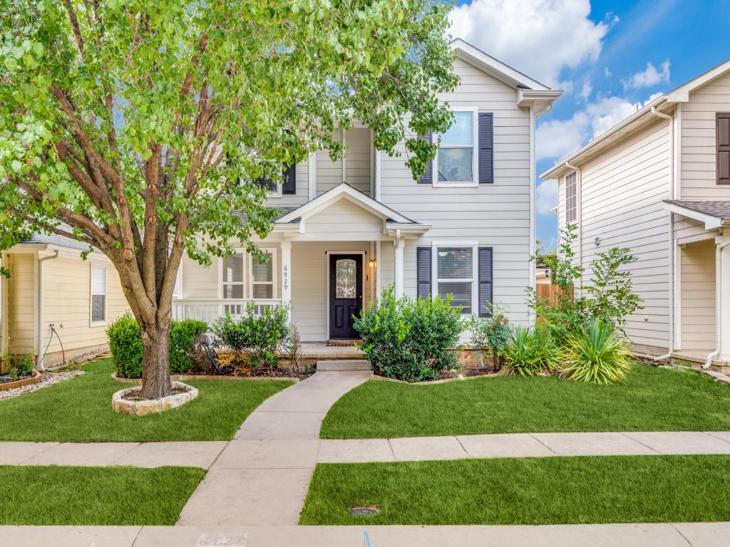 a front view of a house with a yard and potted plants