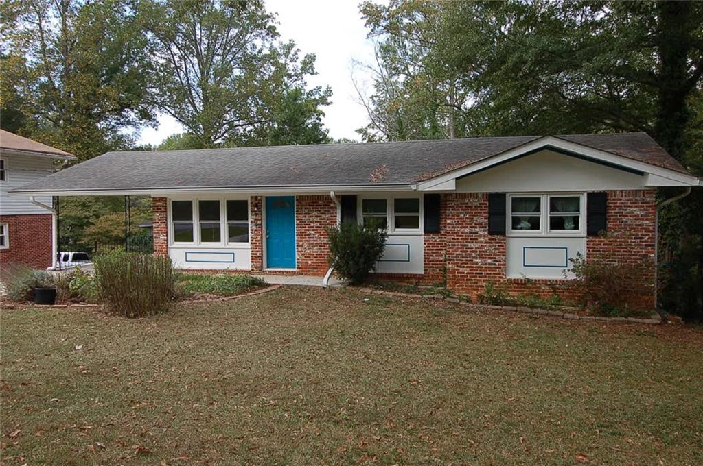 a front view of a house with a garden and tree