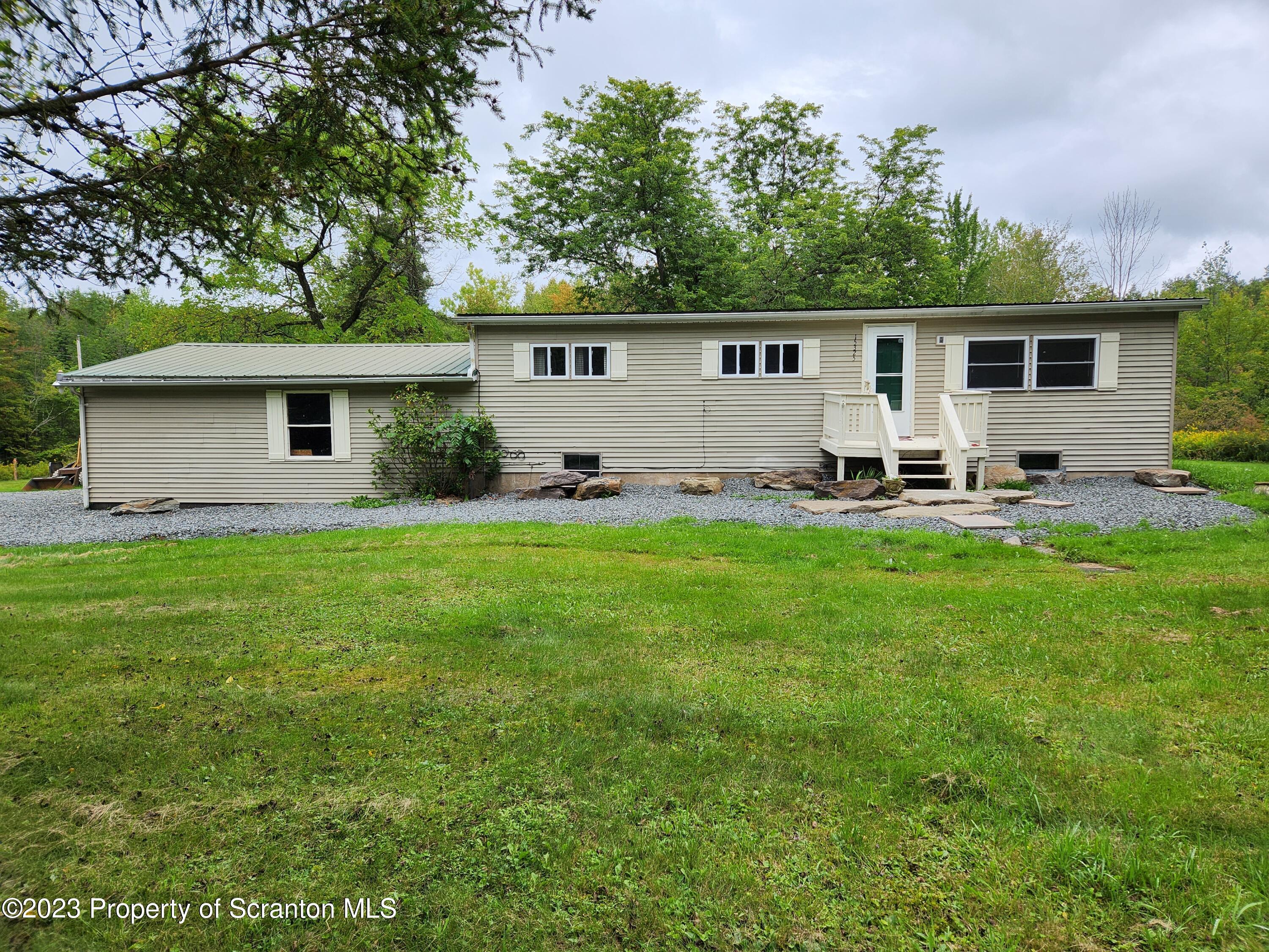 a front view of house with yard and outdoor seating