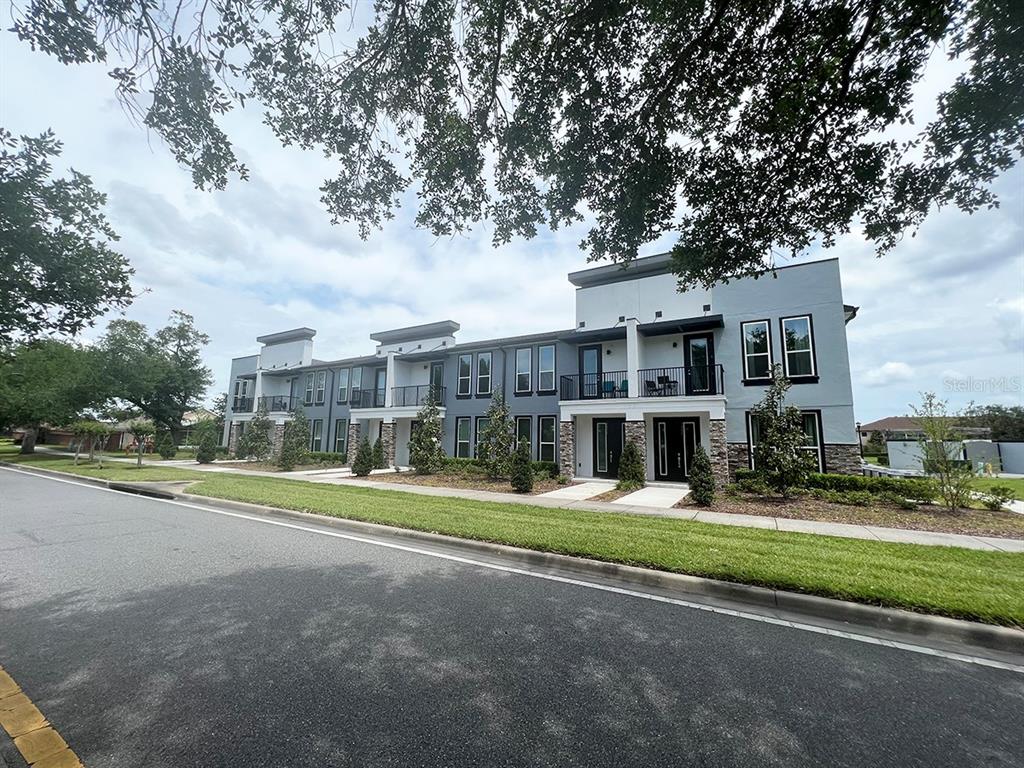 a view of a big house in a big yard with large trees