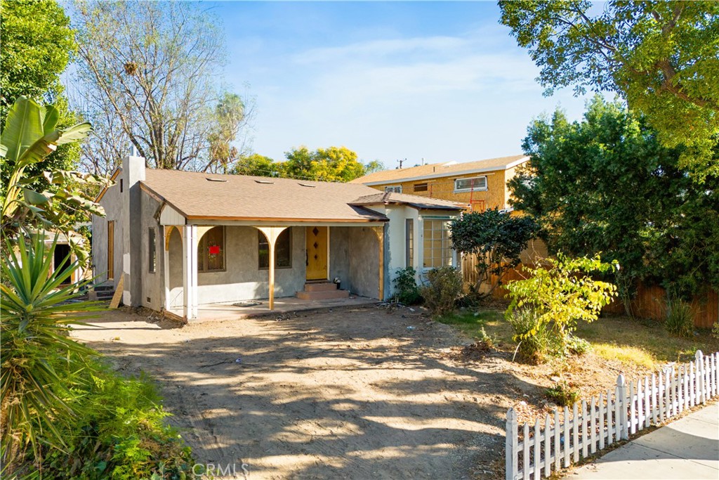 a view of a house with wooden walls and a yard