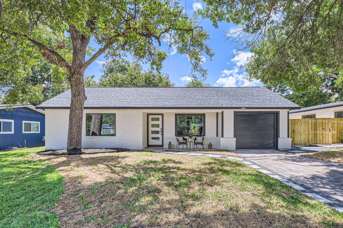 a front view of house with yard and trees around