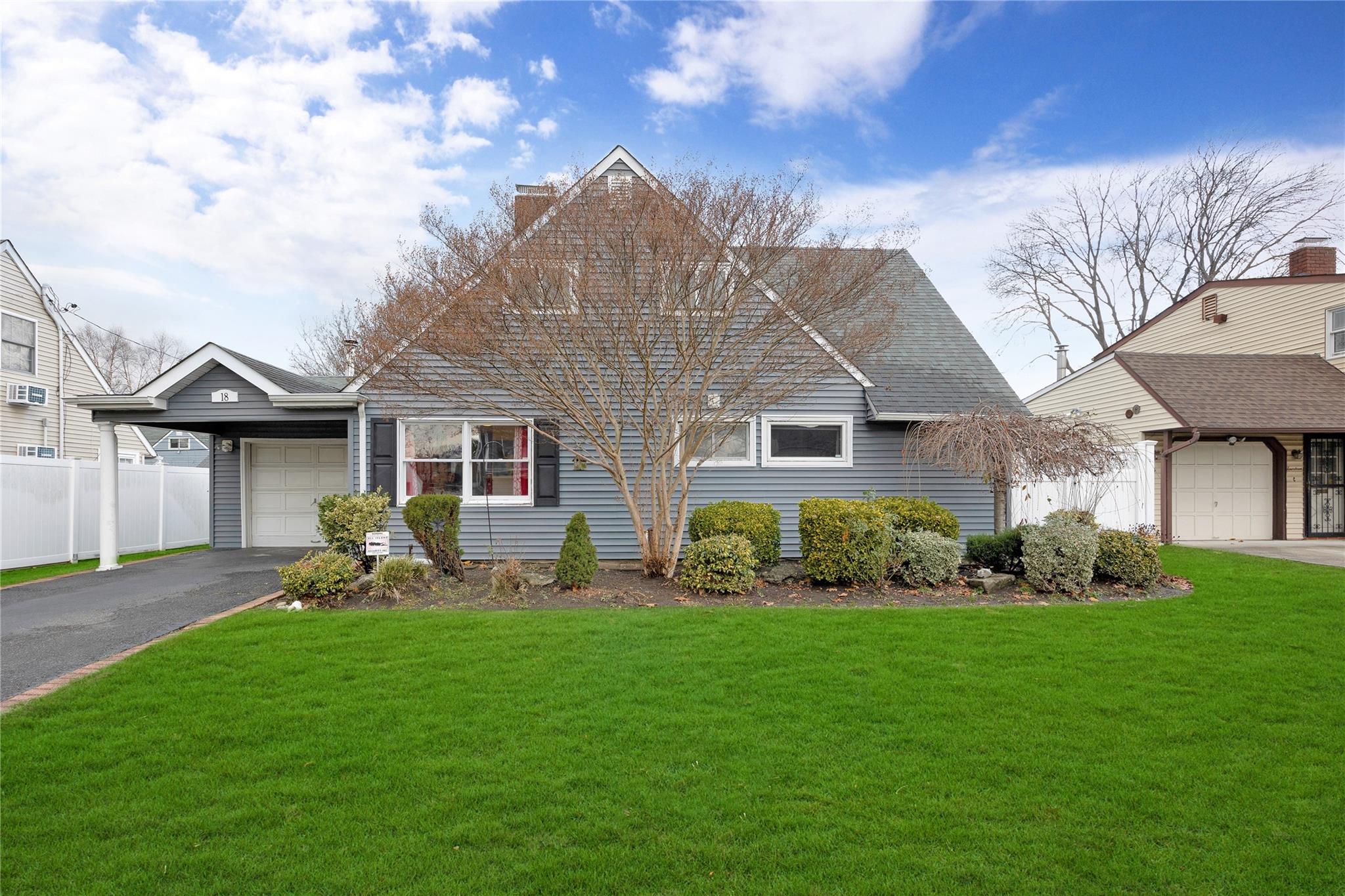 View of front of property featuring a front yard and a garage