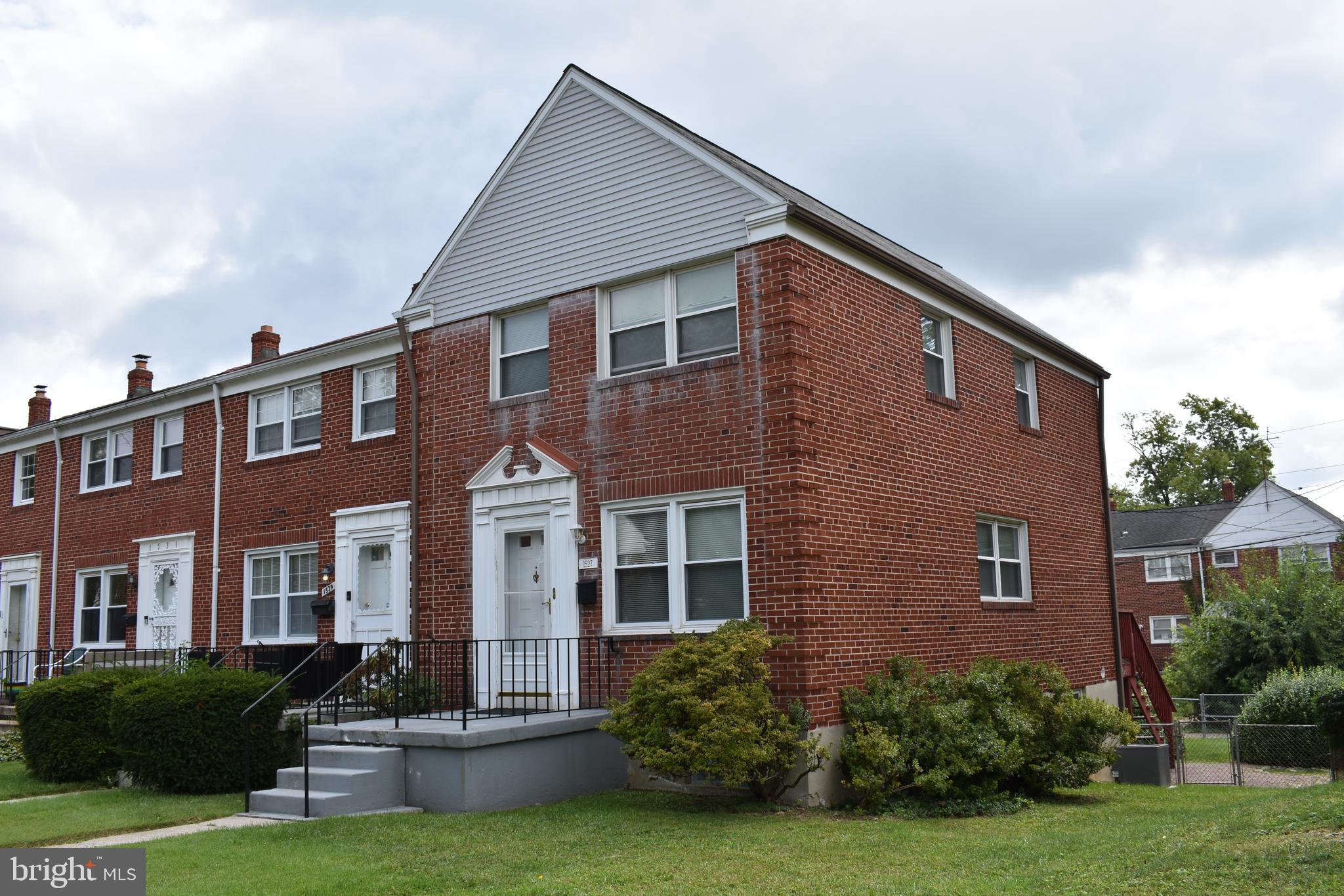 a front view of a house with yard and green space