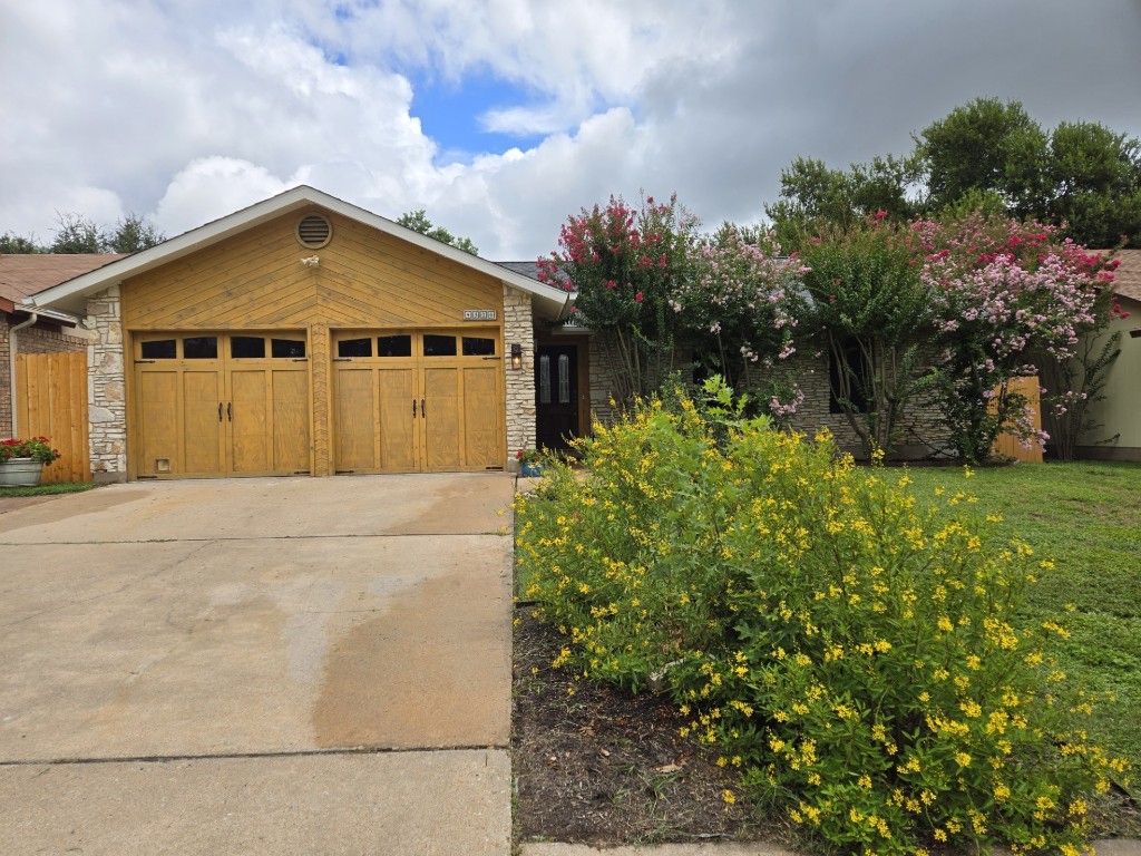 a view of a house with a yard and potted plants