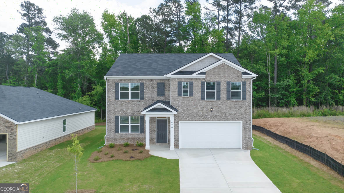 a front view of a house with a yard and trees