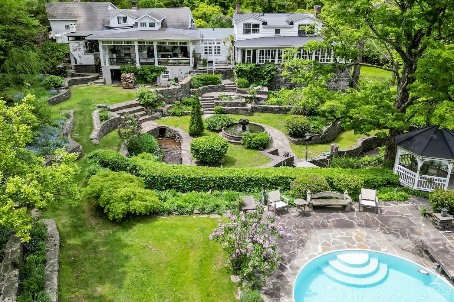 a aerial view of a house with swimming pool outdoor seating and yard