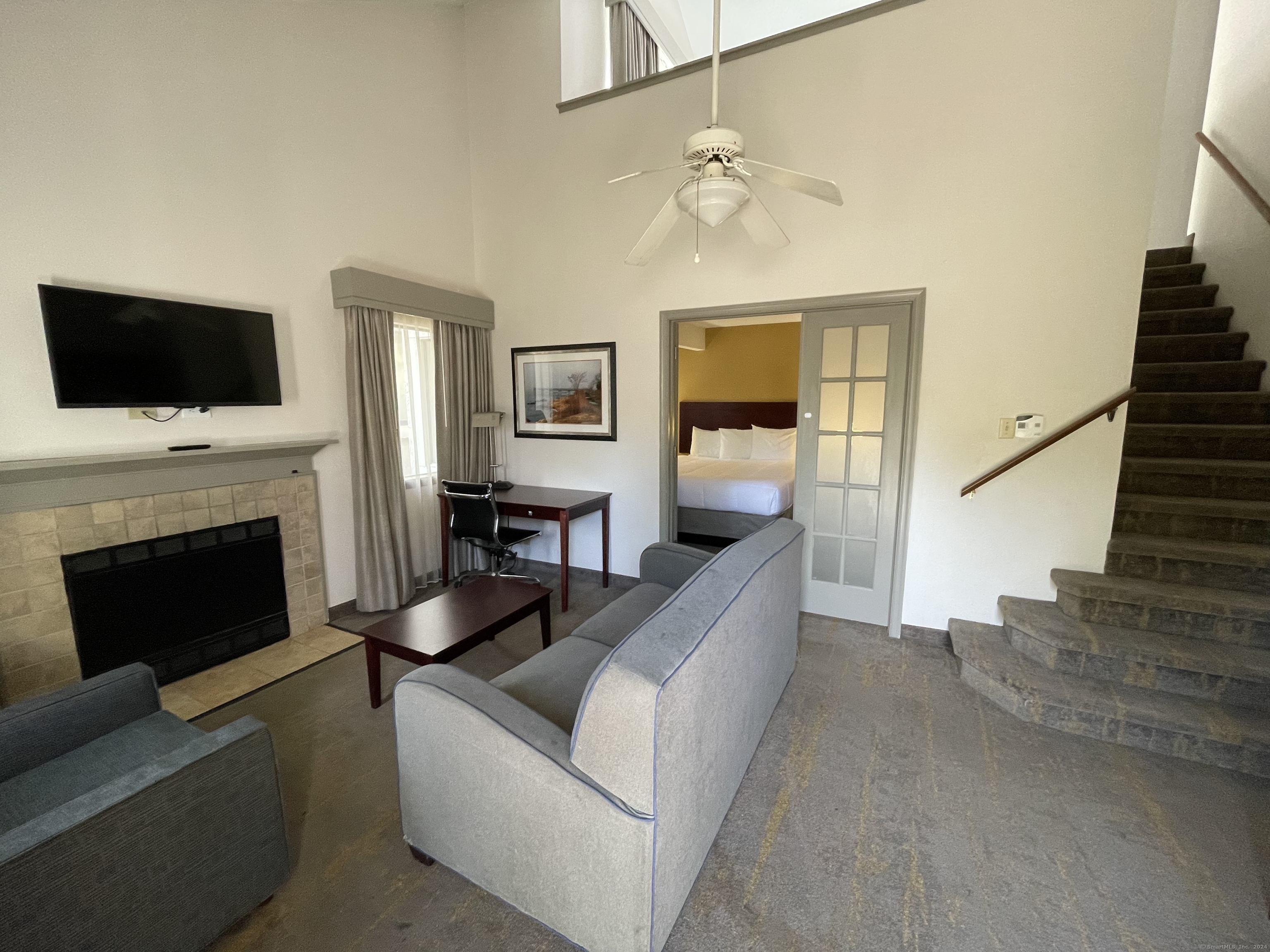 a living room with furniture a flat screen tv and a fireplace