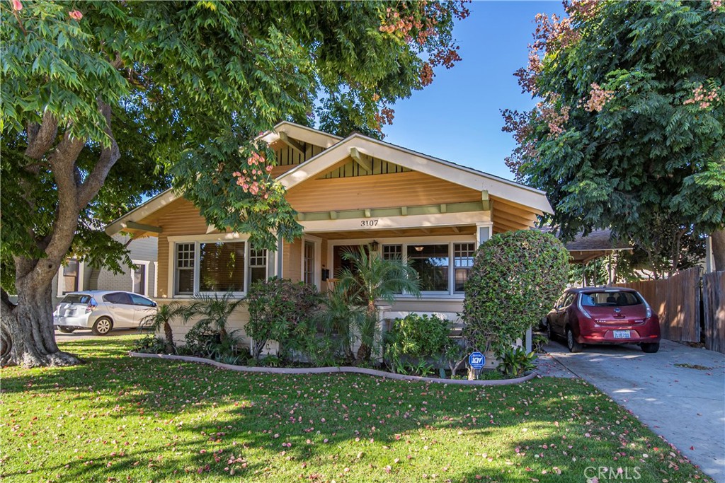 a front view of a house with a yard and potted plants